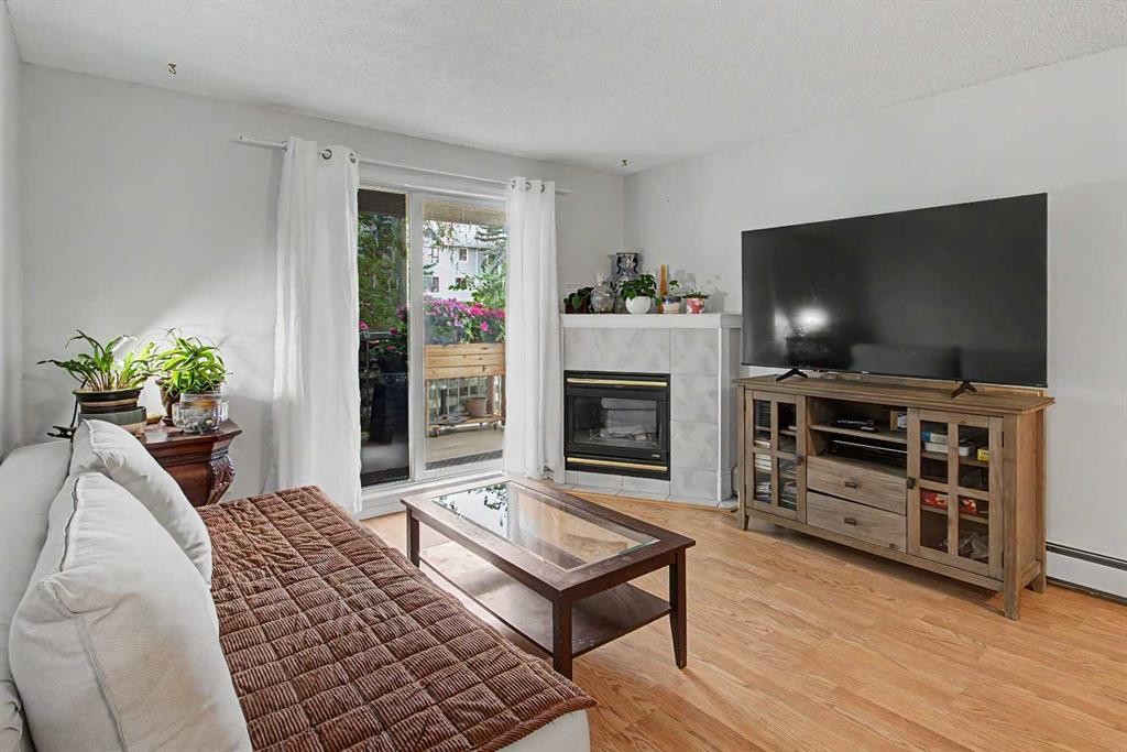 101-7724 Bowness Road Nw, Calgary, AB - Indoor Photo Showing Living Room With Fireplace