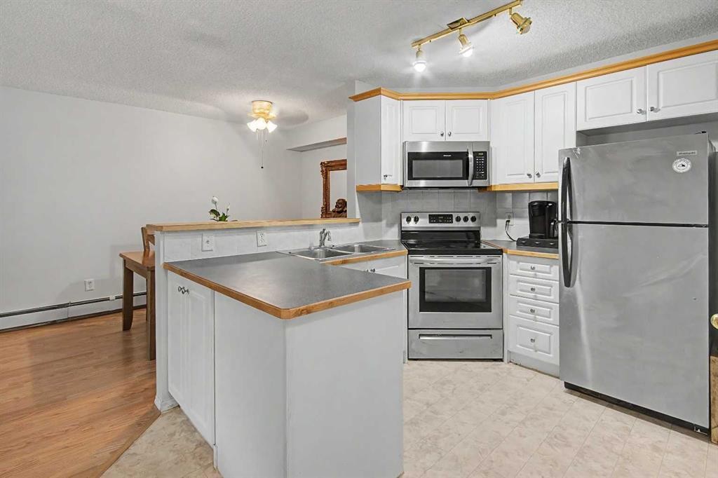 101-7724 Bowness Road Nw, Calgary, AB - Indoor Photo Showing Kitchen With Stainless Steel Kitchen With Double Sink