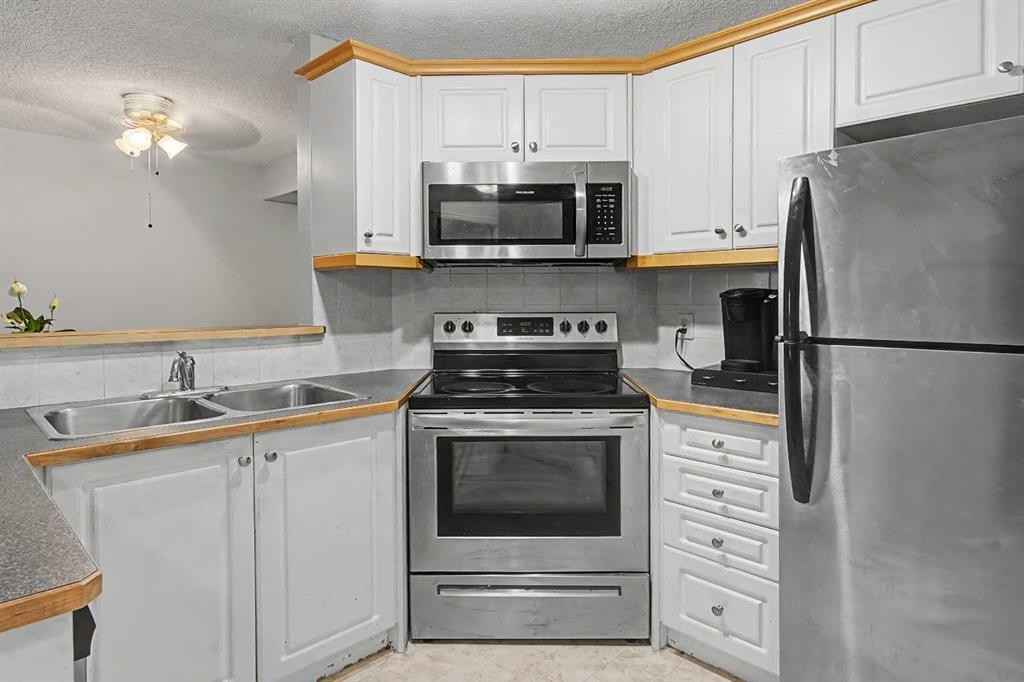 101-7724 Bowness Road Nw, Calgary, AB - Indoor Photo Showing Kitchen With Stainless Steel Kitchen With Double Sink