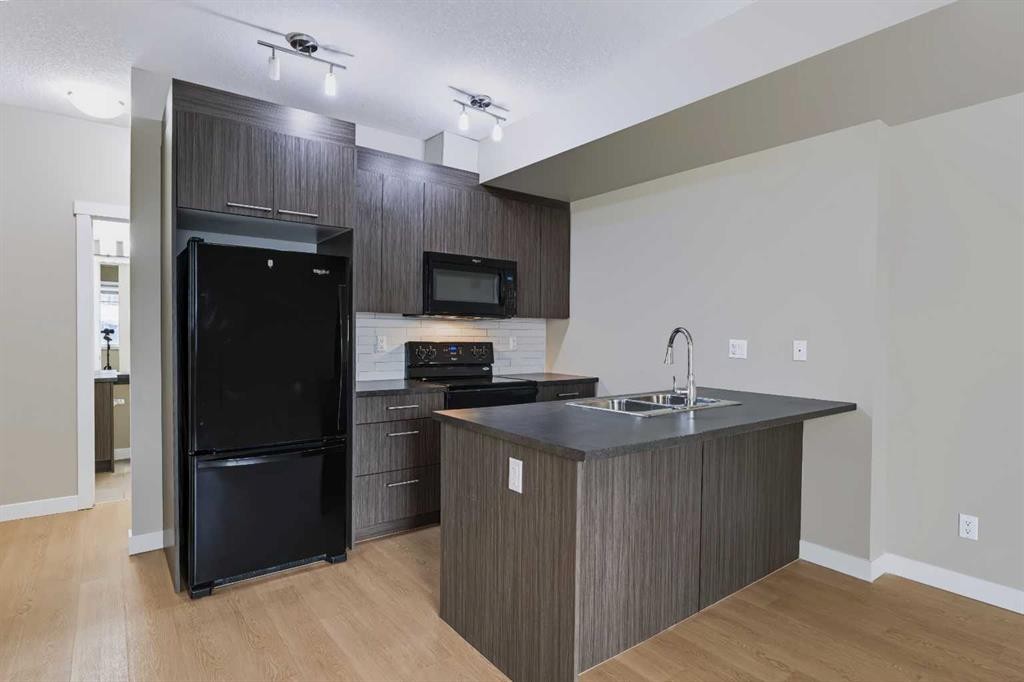 210-300 Marina Drive, Chestermere, AB - Indoor Photo Showing Kitchen With Double Sink