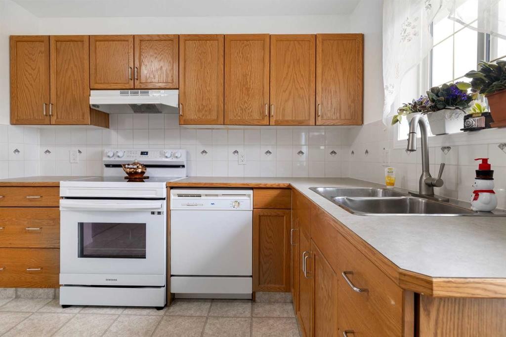 100 Dovista Court Se, Calgary, AB - Indoor Photo Showing Kitchen With Double Sink