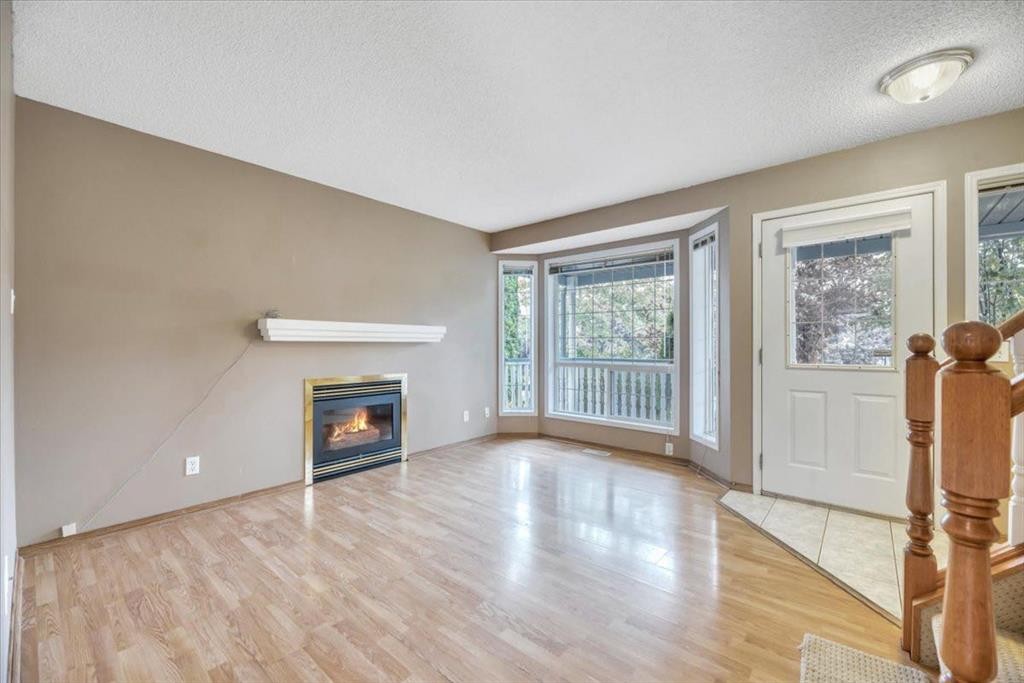 131 Hidden Way Nw, Calgary, AB - Indoor Photo Showing Other Room With Fireplace