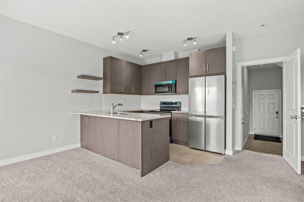 304 Jumping Pound Common, Cochrane, AB - Indoor Photo Showing Kitchen With Stainless Steel Kitchen