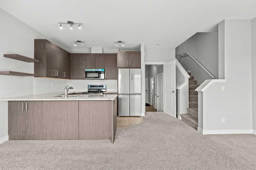 304 Jumping Pound Common, Cochrane, AB - Indoor Photo Showing Kitchen With Stainless Steel Kitchen With Double Sink