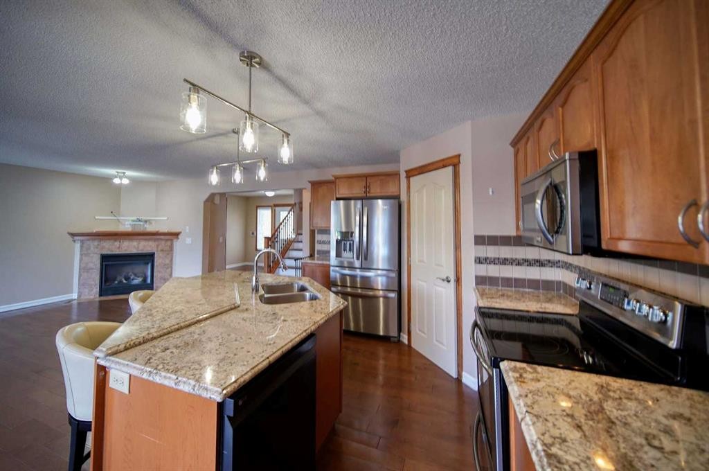 329 Springmere Way, Chestermere, AB - Indoor Photo Showing Kitchen With Fireplace With Double Sink