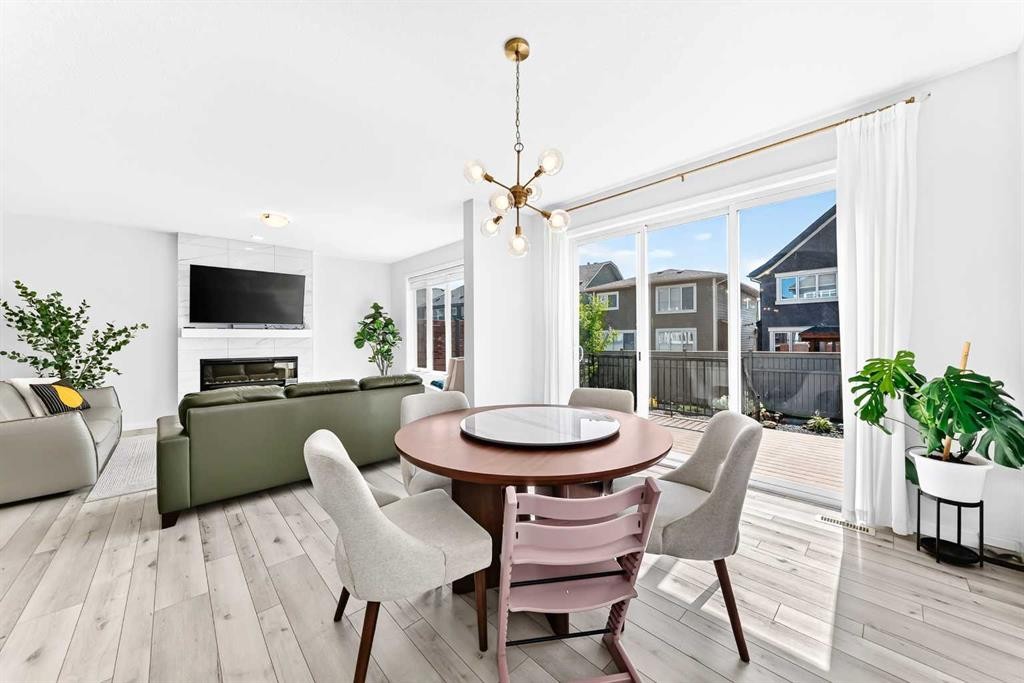 105 Magnolia Manor Se, Calgary, AB - Indoor Photo Showing Dining Room With Fireplace