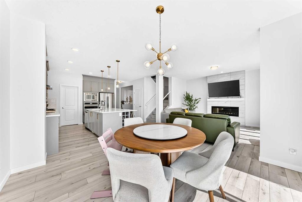 105 Magnolia Manor Se, Calgary, AB - Indoor Photo Showing Dining Room With Fireplace