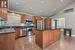 kitchen features granite counters, wood cabinets, stainless steel appliances, island overlooking family room