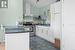 kitchen with tile floors, laminate counters & white cupboards
