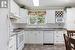 Kitchen featuring backsplash, tile flooring, and white appliances