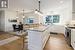 Kitchen with wall chimney exhaust hood, a healthy amount of sunlight, light hardwood / wood-style flooring, and stainless steel range