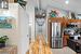 Kitchen with stainless steel appliances, vaulted ceiling, and light tile floors