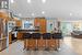 Kitchen with a kitchen island, stainless steel appliances, a kitchen breakfast bar, sink, and light tile floors