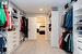 Expansive walk-through closet featuring custom built-ins