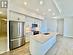 Kitchen featuring white cabinets, appliances with stainless steel finishes, sink, and an island with sink