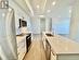 Kitchen featuring stainless steel appliances, white cabinetry, and a center island with sink