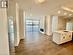 Kitchen featuring a kitchen island with sink, wood-type flooring, crown molding, sink, and white cabinetry