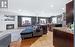 Living room featuring sink, a stone fireplace, light hardwood / wood-style flooring, lofted ceiling, and decorative columns