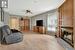 Living room with light wood-type flooring, a tile fireplace, and ceiling fan