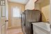 Clothes washing area featuring a textured ceiling, cabinets, sink, light laminate flrng