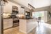 Kitchen featuring updated white cabinetry, stainless steel appliances, and decorative light fixtures