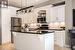 Kitchen featuring b/in stainless steel appliances, white cabinetry, and an island with sink