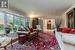 Living room with wood-type flooring, a healthy amount of sunlight, and crown molding