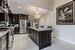 Kitchen featuring a kitchen island, appliances with stainless steel finishes, decorative light fixtures, light stone countertops, and a breakfast bar area