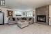 Carpeted living room with a stone fireplace