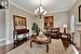 Living room with a fireplace, a notable chandelier, ornamental molding, and dark hardwood / wood-style floors