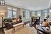 Living room featuring dark hardwood / wood-style flooring, ornamental molding, and a healthy amount of sunlight