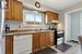 Kitchen featuring dishwasher, sink, backsplash, light hardwood / wood-style floors, and stainless steel range with electric cooktop