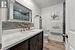 Bathroom with decorative backsplash, an enclosed shower, vanity, hardwood / wood-style flooring, and toilet