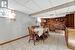 Dining area with light tile patterned floors, a paneled ceiling, and brick wall