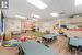 Playroom with a paneled ceiling and light hardwood / wood-style floors