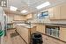 Kitchen with a paneled ceiling, sink, light hardwood / wood-style flooring, ceiling fan, and a kitchen island