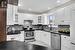 Kitchen with sink, decorative backsplash, light tile patterned floors, appliances with stainless steel finishes, and white cabinetry