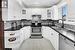 Kitchen with tasteful backsplash, sink, white cabinets, and stainless steel appliances