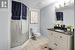 Bathroom featuring tile patterned flooring, vanity, a shower with shower door, and toilet