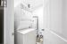 Laundry area with light tile patterned floors, electric water heater, and stacked washing maching and dryer