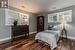 Bedroom with dark wood-type flooring and multiple windows