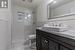 Bathroom featuring a tile shower, vanity, and toilet