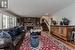 Living room featuring dark hardwood / wood-style floors, ornamental molding, a textured ceiling, and a brick fireplace