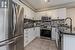 Kitchen featuring sink, white cabinetry, stainless steel appliances, and dark stone counters