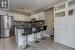 Kitchen with a breakfast bar, white cabinetry, appliances with stainless steel finishes, and dark stone counters