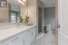 Bathroom with tile patterned floors, vanity, toilet, and a tile shower