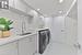 Washroom featuring light tile patterned flooring, cabinets, independent washer and dryer, and sink