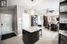 Kitchen featuring a kitchen breakfast bar, ceiling fan with notable chandelier, light tile patterned floors, a kitchen island, and hanging light fixtures