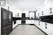 Kitchen with white cabinets, black appliances, wall chimney range hood, and light hardwood / wood-style floors