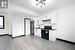 Kitchen featuring stainless steel refrigerator, white cabinetry, electric range, sink, and light hardwood / wood-style floors